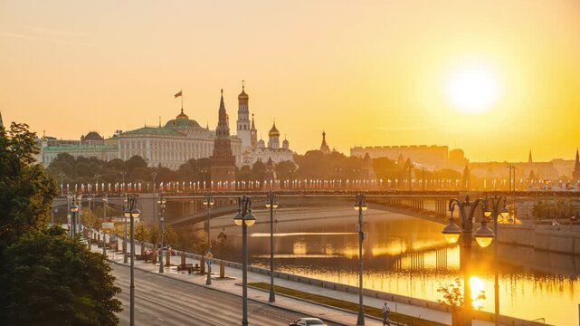 A morning view of the Moscow River, the Kremlin, St. Michael the Archangel's Cathedral, and the Grand Kremlin Palace, with the sun rising over the horizon &mdash; time-lapse photography