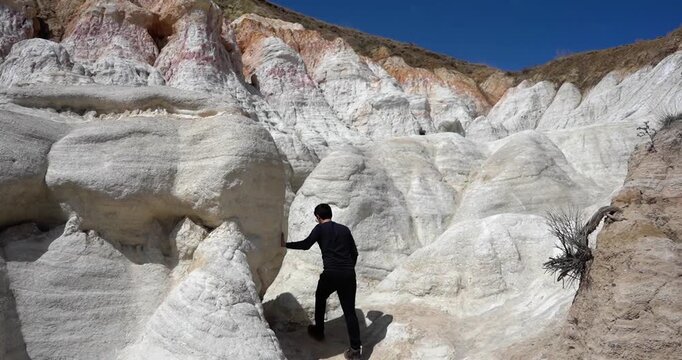 Man walking through colorful rock formations at Paint Mines Interpretive Park, Colorado
