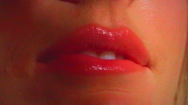Close-up woman's pink lips and perfect white teeth seducing the viewer. VHS video noise effect