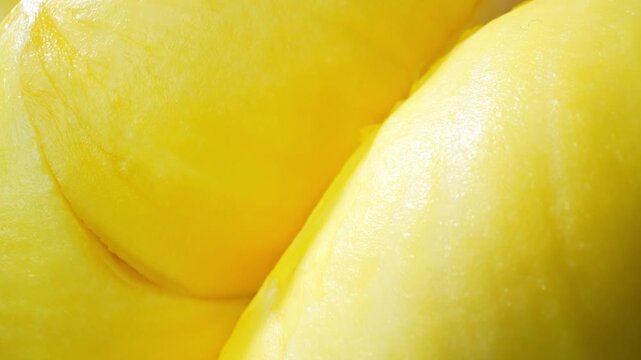A golden durian flesh displaying intricate texture and natural fruit quality. Ideal for nutrition, organic farming, and exotic fruit advertising concepts. 4k.

