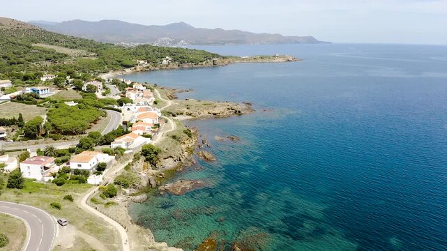 Aerial view of La Vall Beach, the main urban beach of Port de la Selva, with golden sand, calm Mediterranean waters and the village waterfront. 
