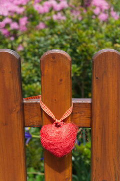 Red sisal heart on wooden fence