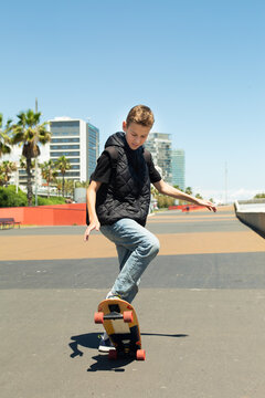 Handsome teenager standing with skateboard. Adolescent discovers city streets