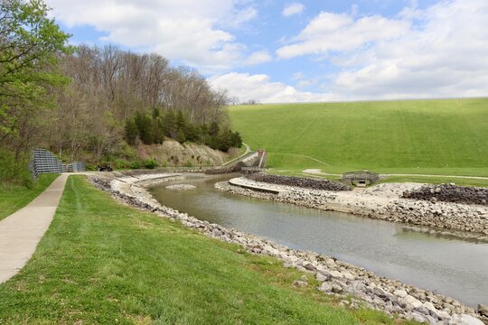 The flowing stream at the dam in the park on a sunny day.