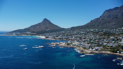 Fototapeta premium Aerial stock image of Camps Bay, Bakoven and Lions Head, Cape town Coastline camera approaching from the sea over the beach and neigbourhood on a summer day