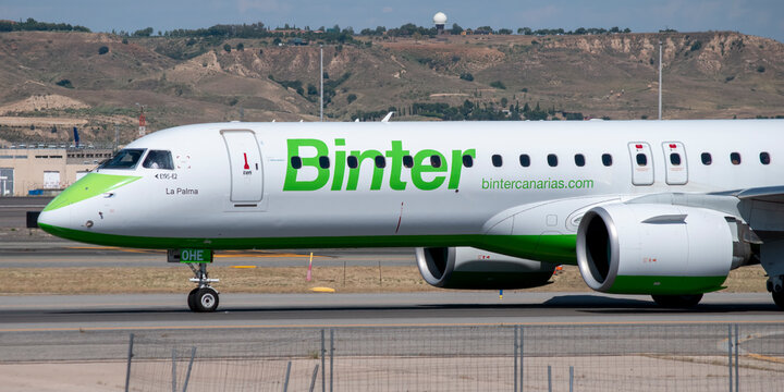 Avi&oacute;n comercial de la aerol&iacute;nea Binter Canarias realizando maniobras de rodaje en la pista del aeropuerto de Madrid con monta&ntilde;as al fondo.