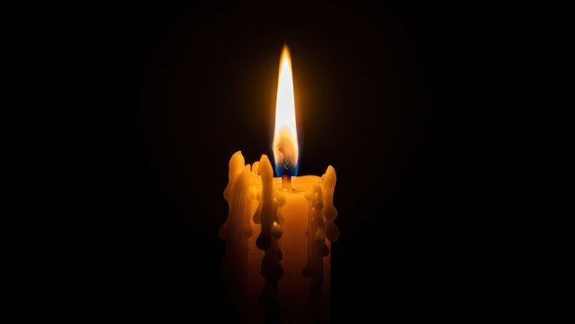 Single lit candle flame glowing with heavy melting wax.