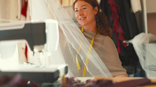 Happy seamstress working on sewing machine