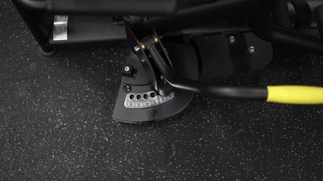 Close up of fitness machine adjustment mechanism as athlete changes exercise position and equipment settings before starting strength training workout