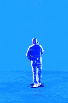 Glitch effect silhouette of a man seen from behind while making a phone call