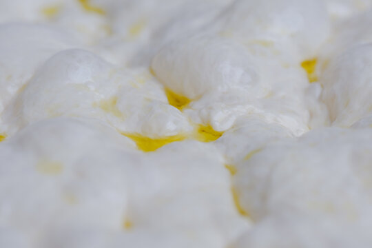 Naturally fermented sourdough focaccia dough during the final proofing stage. The dough surface is filled with air bubbles artisan bread-making process and traditional natural leavening techniques.