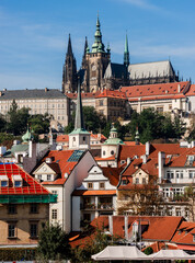 Obraz premium Prague Castle dominates city red roofs under bright sky