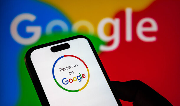 Closeup of a smartphone screen displaying a review us on google icon with the google logo in the background