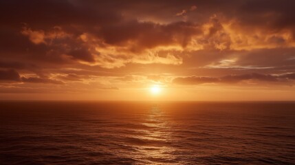 Fototapeta premium A vibrant sunset over a calm ocean, with golden light reflecting on the water beneath partly cloudy skies.
