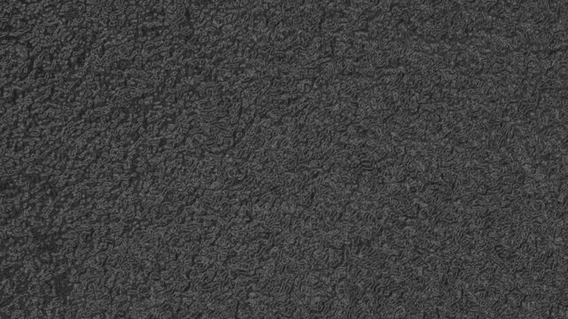 Dark textured surface with dense organic patterns, subtle ridges, and uniform matte appearance. Grunge texture background animation.