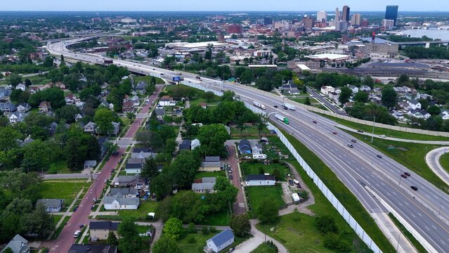 Aerial View of Downtown Toledo Ohio Cityscape with cars traveling interstate highway past urban homes