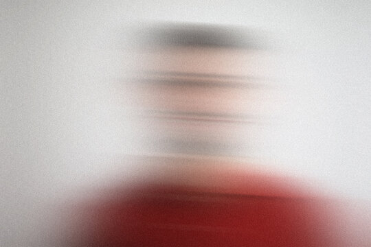 Blurry portrait of person wearing red shirt background white motion blur effect abstract textured grainy.