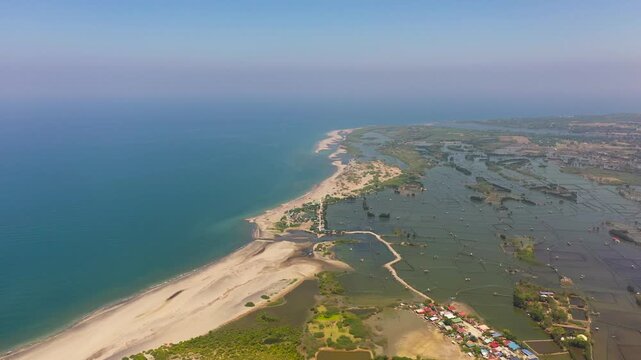 Top view of coastline with fishing villages and fish farms. Luzon, Philippines.
