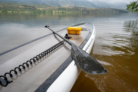 touring stand up paddleboard with waterproof box,  safety leash and paddle on a calm Horsetooth Reservoir in summer scenery in northern Colorado