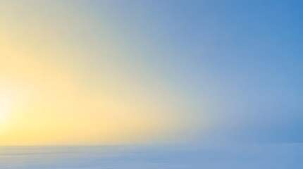 Obraz premium Abstract morning sunrise over winter horizon with soft yellow glow and blue sky background for commercial copy space