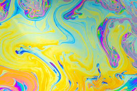 Abstract fluid marble pattern with bright yellow, cyan, pink, and blue swirls
