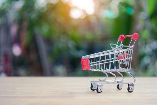 Shopping cart on table with blurred garden background and warm sunlight