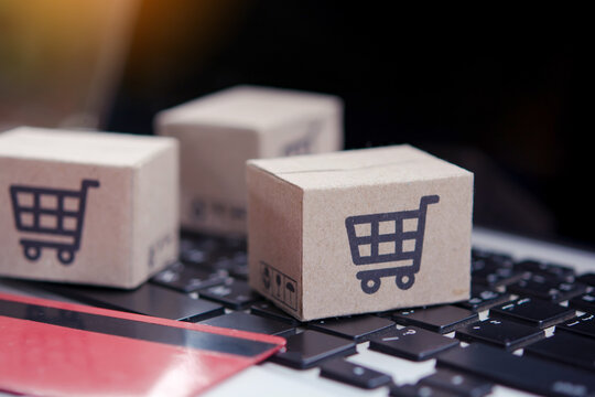 Shopping online. Credit card and cardboard box with a shopping cart logo on laptop keyboard. Shopping service on The online web. offers home delivery