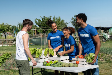 Obraz premium Diverse volunteers harvesting and preparing fresh organic vegetables from a community garden