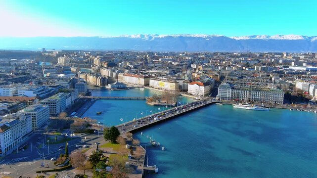 4K aerial drone footage over Geneva, Switzerland - Lake L&eacute;man, Pont du Mont-Blanc, Rh&ocirc;ne River outlet, lakefront quays, luxury hotels, paddle steamer, and snow-capped Alps on the horizon.