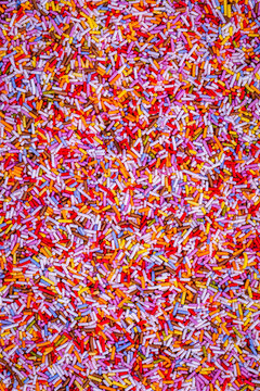 Colorful sprinkles cover a surface in a playful arrangement for a baking project or decoration