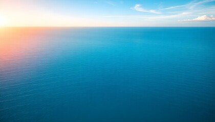 Fototapeta premium A serene ocean view at sunrise with calm waters and clear sky horizon