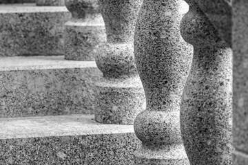 Naklejka premium Granite balusters and stone steps captured in monochrome, emphasizing architectural detail, texture, rhythm and symmetry. A timeless, durable abstract stairway composition
