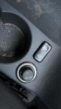 Car cigarette lighter pops out from the dashboard socket after heating, automotive accessory operation, vehicle interior control, electrical mechanism.