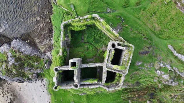 Aerial drone footage captures a push forward and tilt down movement over the historic Castle Tioram. Set on the west coast of Scotland, UK on a the spring afternoon.