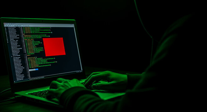 Hacker Analyzing Code on Laptop with Green-Themed Lighting