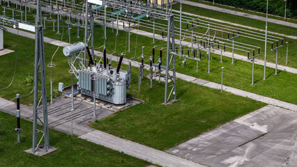 Aerial view of an operational electrical substation with transformers and high-voltage equipment for power distribution. © 24K-Production