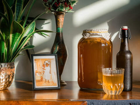 Kombucha and family photo on wooden counter at home 