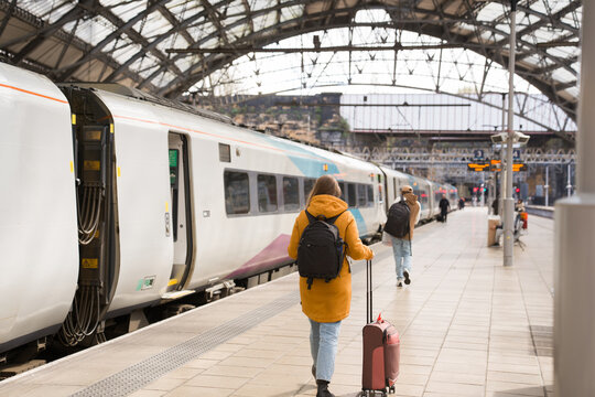 Person Walking at Train Station With Suitcase 