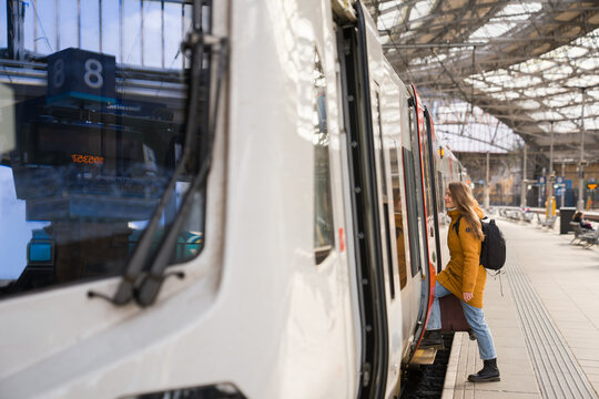 Woman Boards Train at Station 