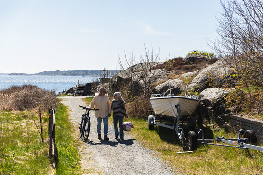 Senior Couple with Picnic Gear Walking Near the Sea
