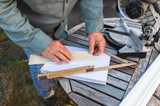 Close Up of Hands Measuring Wood with Ruler