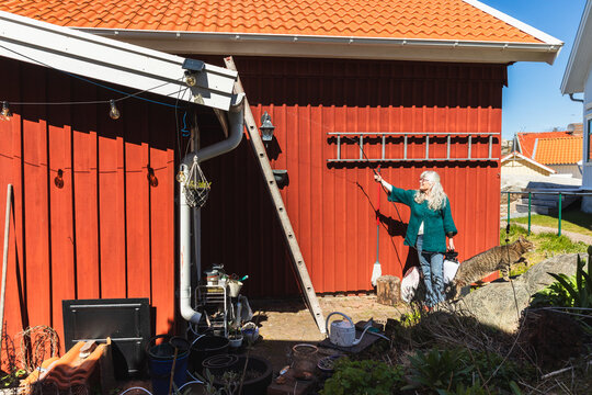 Senior Woman watering Green Sedum Roof