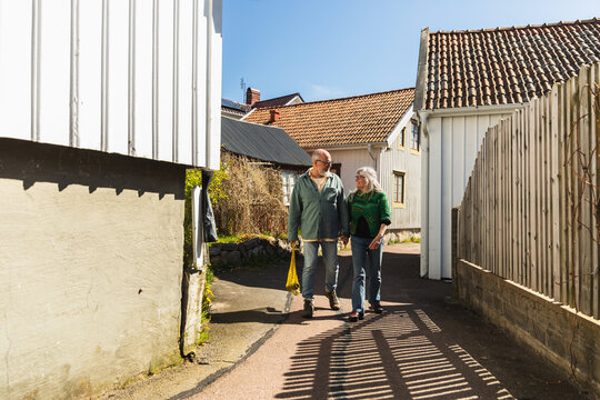 Senior Couple Walking in Village with mesh Bag