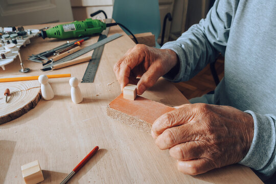 Old Carpenter Working with Sandpaper