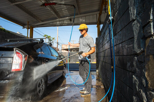Man Rinsing Car at Carwash
