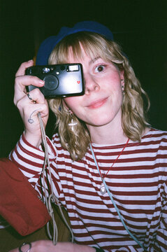 Young woman taking picture with film camera