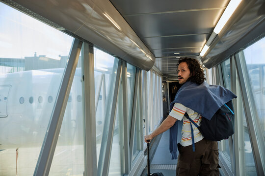 Traveler walking through airport jet bridge before boarding