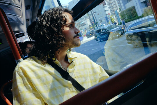 Traveler looking through bus window in Tokyo Japan