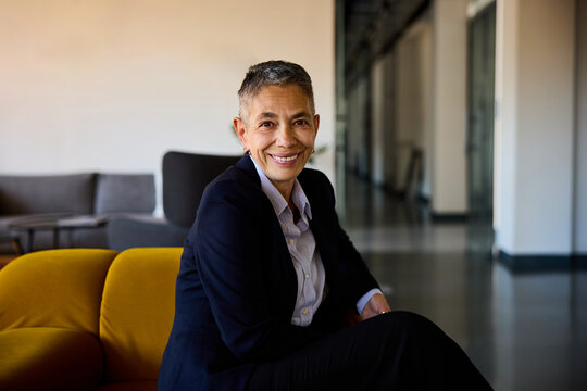 Senior woman sits back in a corporate lobby