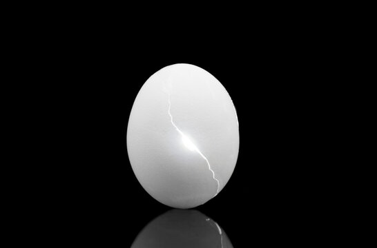 Concept Photo of Cracked Egg on Black  